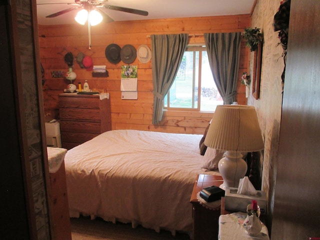 bedroom featuring wooden walls and ceiling fan