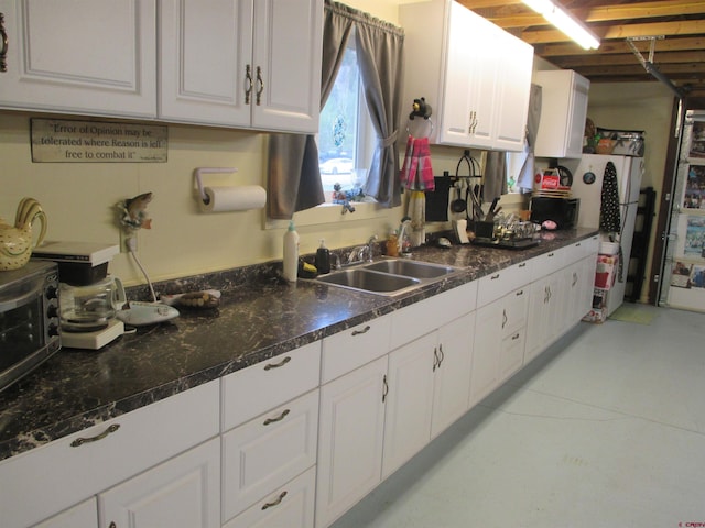 kitchen featuring white cabinetry and sink