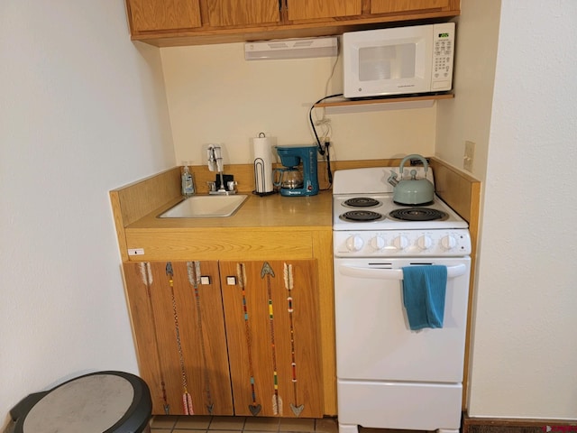 kitchen with sink, light tile patterned floors, and white appliances