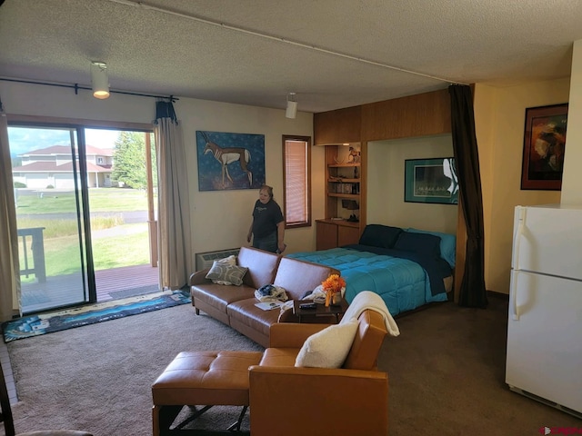 bedroom featuring carpet flooring, white refrigerator, access to exterior, and a textured ceiling