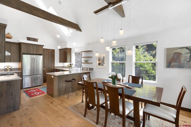 dining space featuring light wood-type flooring, beamed ceiling, high vaulted ceiling, and ceiling fan