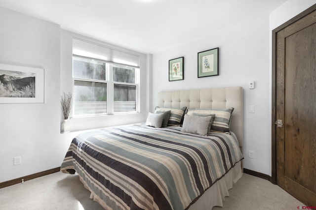 bedroom featuring baseboards and carpet