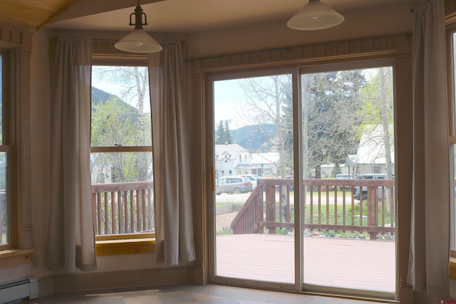 doorway to outside featuring tile floors, a baseboard radiator, and vaulted ceiling