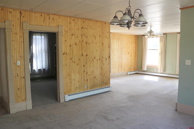 empty room featuring a baseboard heating unit, carpet, and ceiling fan with notable chandelier