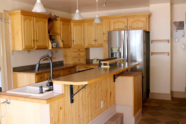 kitchen featuring light brown cabinets, sink, dark tile flooring, and pendant lighting