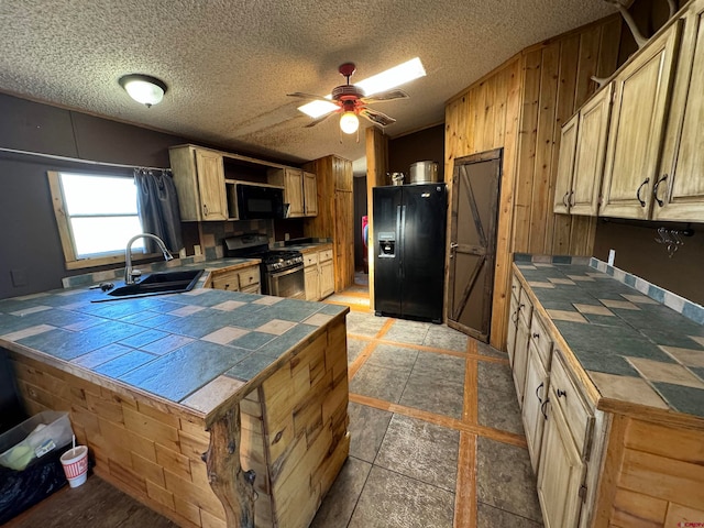 kitchen featuring black appliances, tile countertops, sink, ceiling fan, and vaulted ceiling