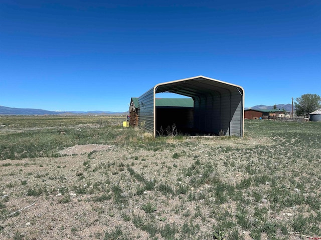 view of yard with a rural view and a carport