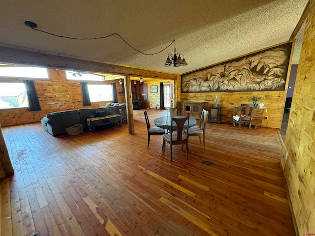 interior space with a textured ceiling, a healthy amount of sunlight, and hardwood / wood-style floors