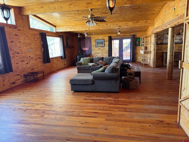 living room with wooden ceiling, lofted ceiling with beams, a healthy amount of sunlight, and wood-type flooring