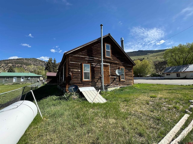 rear view of house with a yard and a mountain view