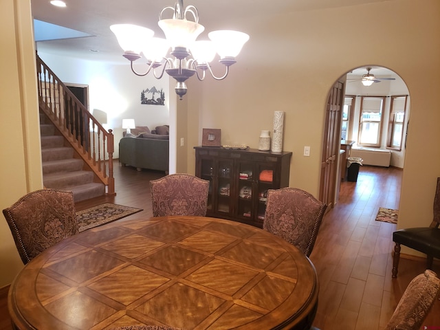 dining room featuring dark hardwood / wood-style floors and ceiling fan with notable chandelier