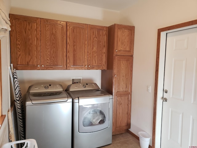 washroom featuring light tile patterned flooring, cabinets, and independent washer and dryer