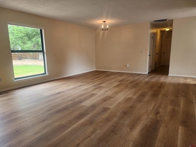 spare room featuring a textured ceiling and hardwood / wood-style flooring