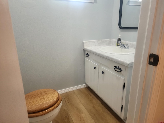 bathroom featuring wood-type flooring, toilet, and vanity