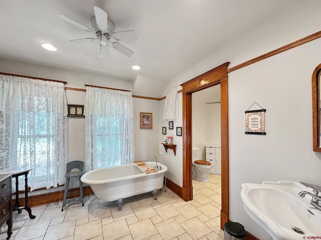 bathroom with ceiling fan, a bath, toilet, and sink