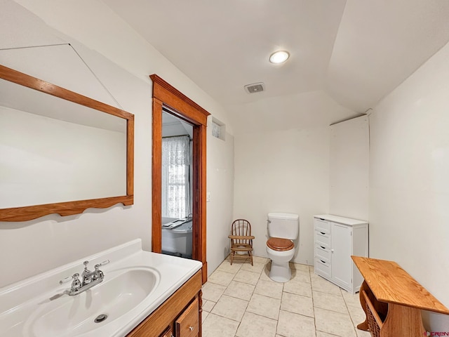 bathroom with tile patterned floors, vanity, lofted ceiling, and toilet