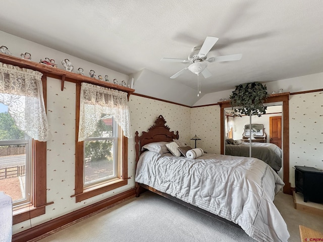 bedroom featuring carpet flooring, a textured ceiling, vaulted ceiling, and ceiling fan