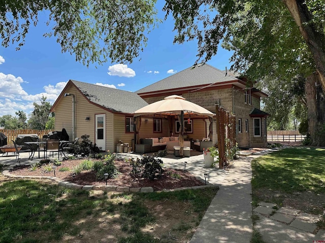 back of property featuring a lawn, an outdoor hangout area, and a patio