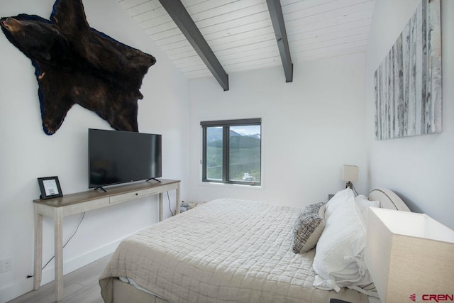 bedroom with vaulted ceiling with beams, light hardwood / wood-style floors, and wooden ceiling