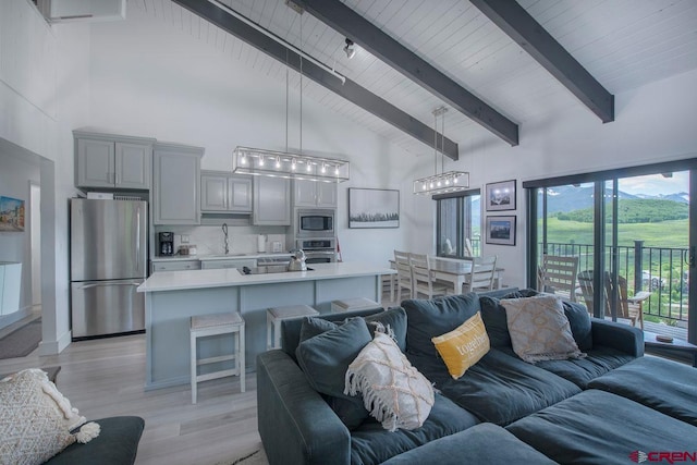 living room featuring beamed ceiling, sink, high vaulted ceiling, and light hardwood / wood-style flooring