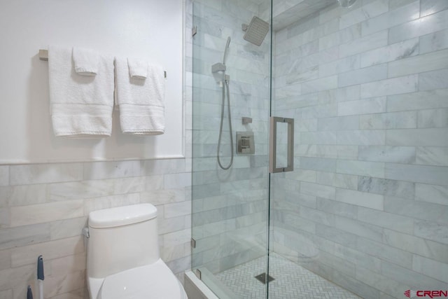 bathroom featuring walk in shower, tile walls, and toilet