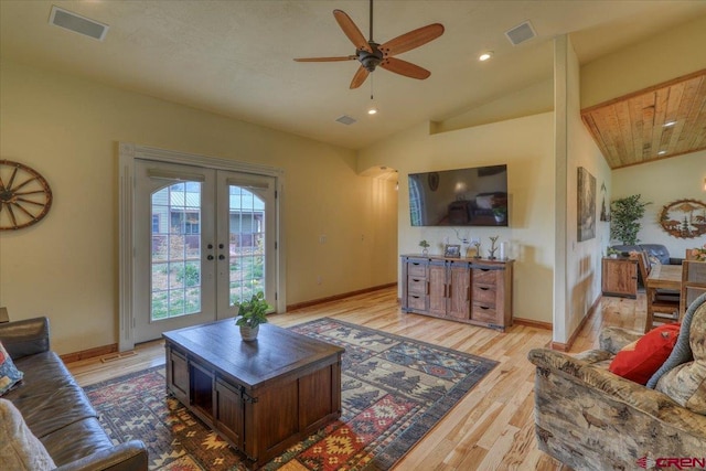 living room with vaulted ceiling, french doors, ceiling fan, and light wood-type flooring