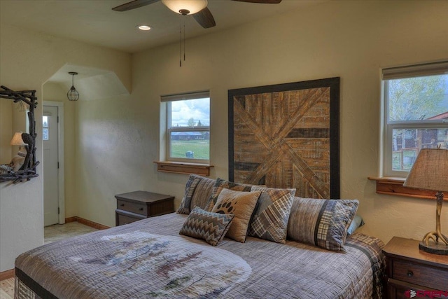 bedroom featuring a water view and ceiling fan