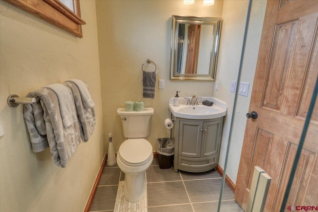 bathroom featuring vanity, tile patterned floors, and toilet