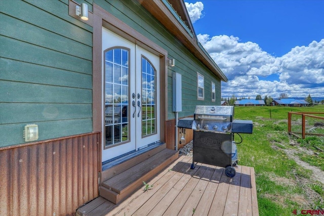 wooden deck featuring a yard, grilling area, and french doors