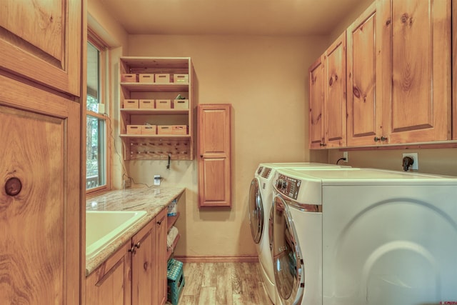 washroom with cabinets, separate washer and dryer, sink, and light hardwood / wood-style flooring