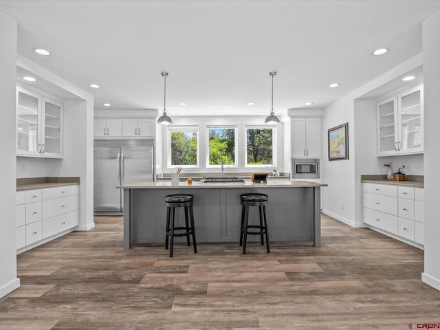 kitchen featuring white cabinetry, dark hardwood / wood-style floors, built in appliances, and a kitchen island