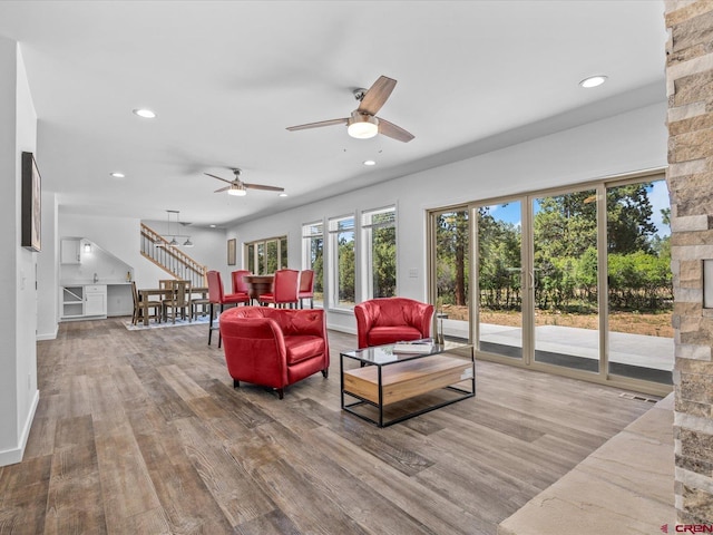 living room featuring wood-type flooring and ceiling fan