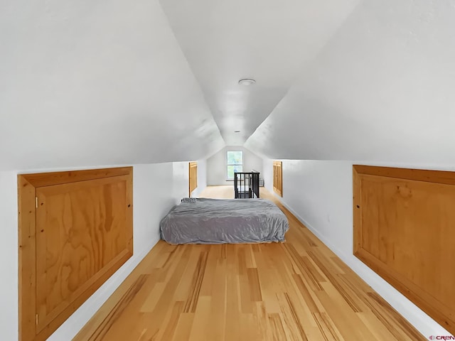 unfurnished bedroom featuring hardwood / wood-style flooring and vaulted ceiling