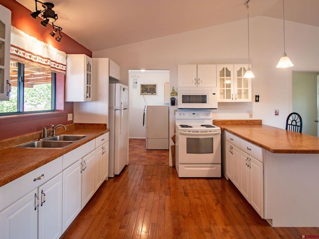 kitchen with white appliances, sink, lofted ceiling, and white cabinetry