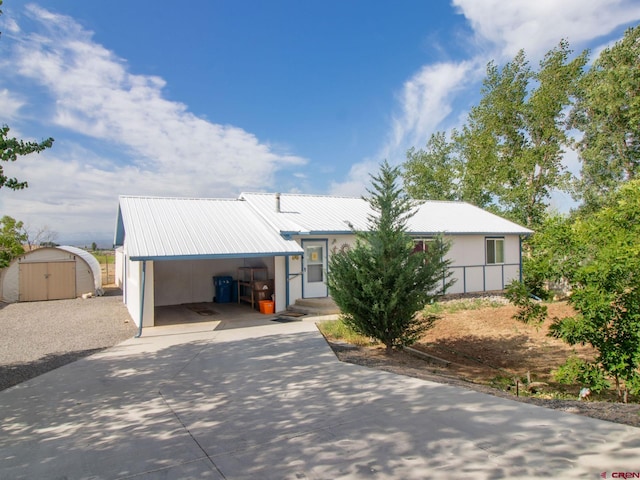 view of front of home featuring a carport and a storage shed