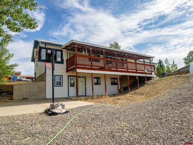 back of house with a deck and a patio area