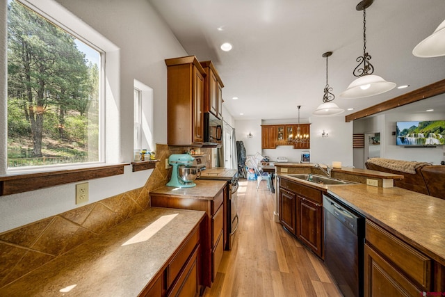 kitchen featuring a wealth of natural light, light wood-style flooring, black appliances, and a sink