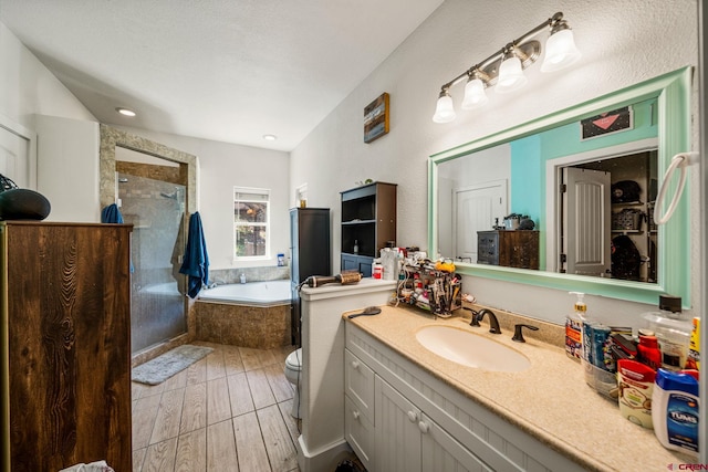 full bath featuring a garden tub, toilet, wood finished floors, a tile shower, and vanity