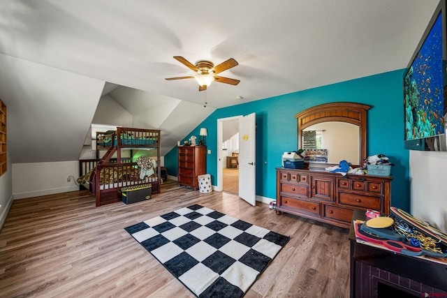 bedroom featuring vaulted ceiling, baseboards, and wood finished floors