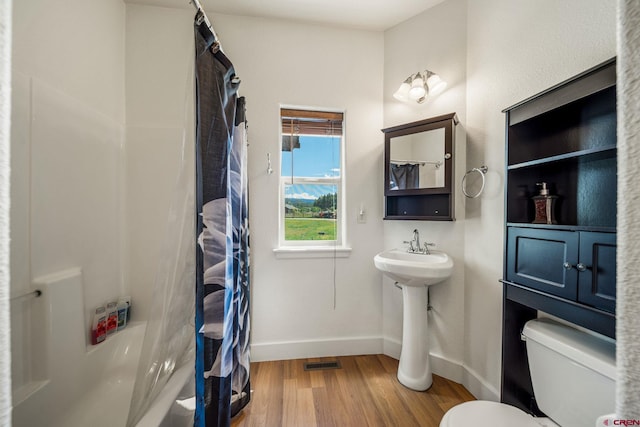 full bathroom featuring wood finished floors, visible vents, baseboards, a sink, and toilet