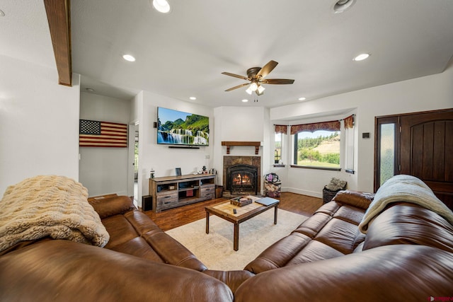 living room with recessed lighting, a ceiling fan, a lit fireplace, and wood finished floors