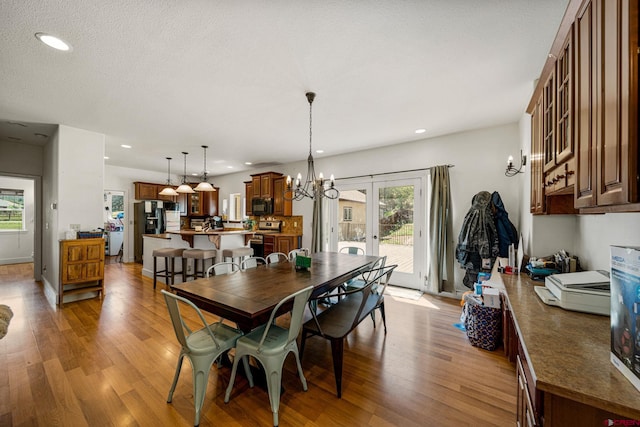 dining area featuring a wealth of natural light, french doors, and light wood-style floors