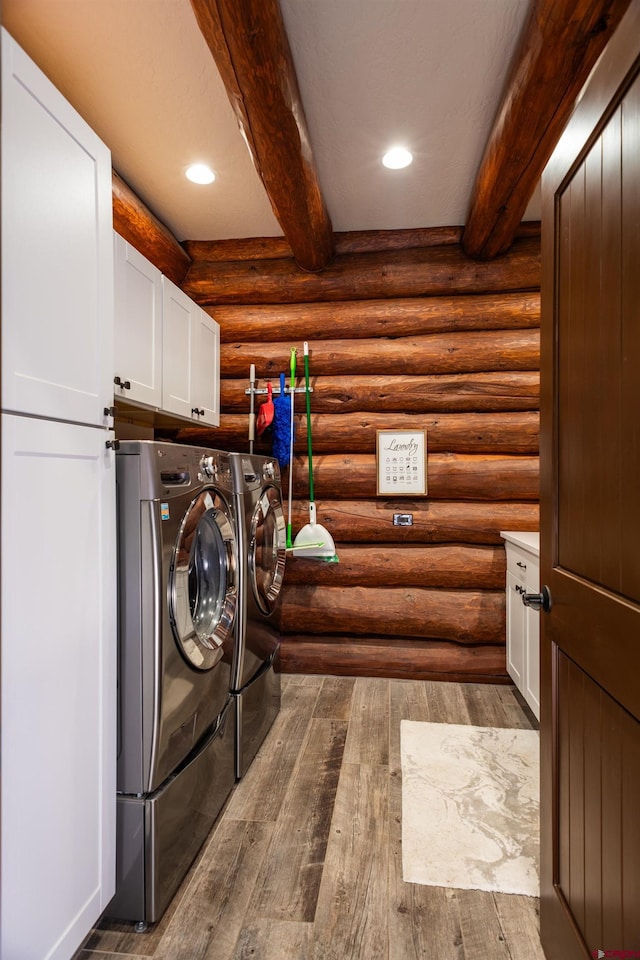 laundry room featuring dark hardwood / wood-style floors, cabinets, independent washer and dryer, and rustic walls