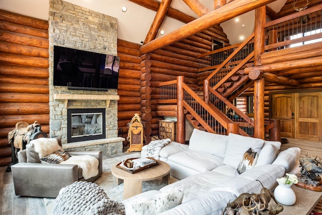 living room featuring beam ceiling, log walls, high vaulted ceiling, hardwood / wood-style floors, and a fireplace