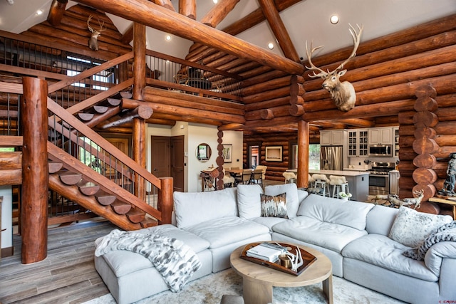 living room with beam ceiling, high vaulted ceiling, and log walls