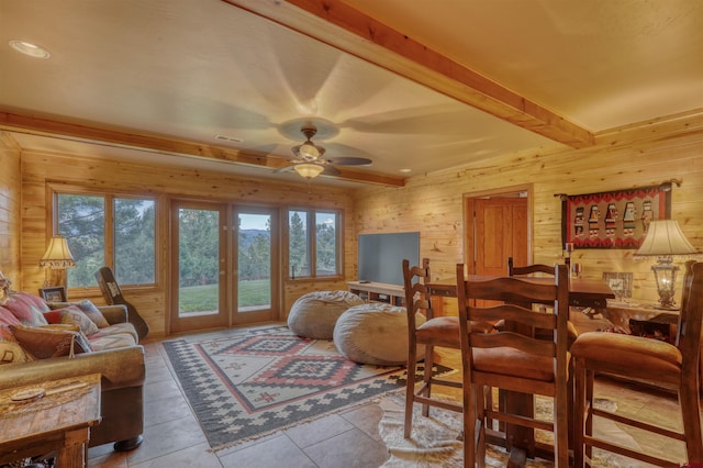 living room with wooden walls, french doors, light tile patterned floors, and ceiling fan