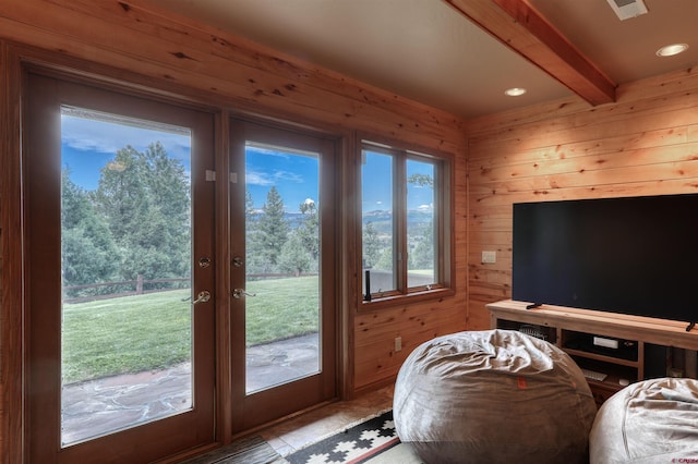 interior space with beam ceiling, wooden walls, and french doors