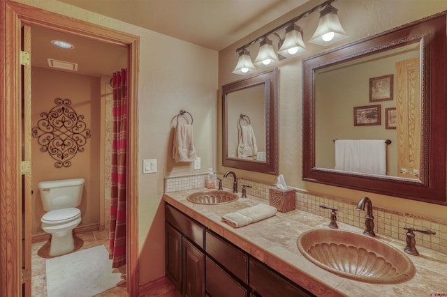 bathroom featuring decorative backsplash, tile patterned flooring, vanity, and toilet