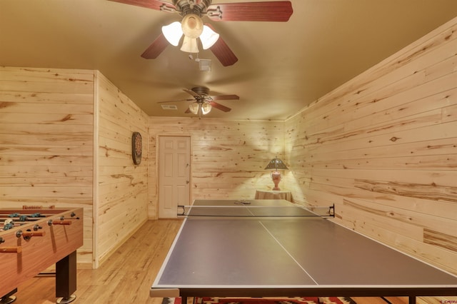 playroom with light hardwood / wood-style floors and wooden walls