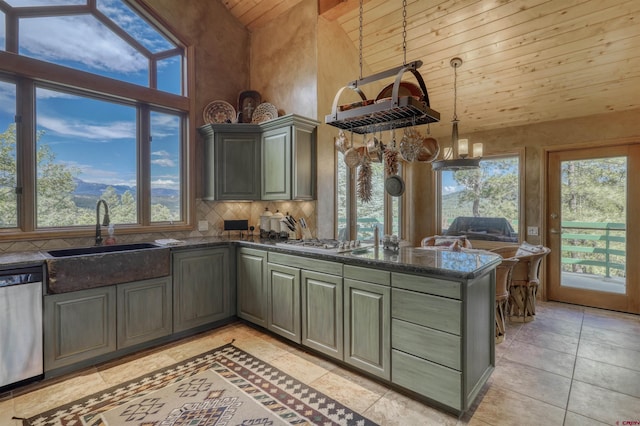 kitchen with kitchen peninsula, stainless steel appliances, sink, pendant lighting, and high vaulted ceiling